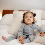 Baby wearing ribbed bamboo zipper romper in stone grey color