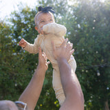 Baby wearing bamboo zip romper/sleeper in apricot beige color