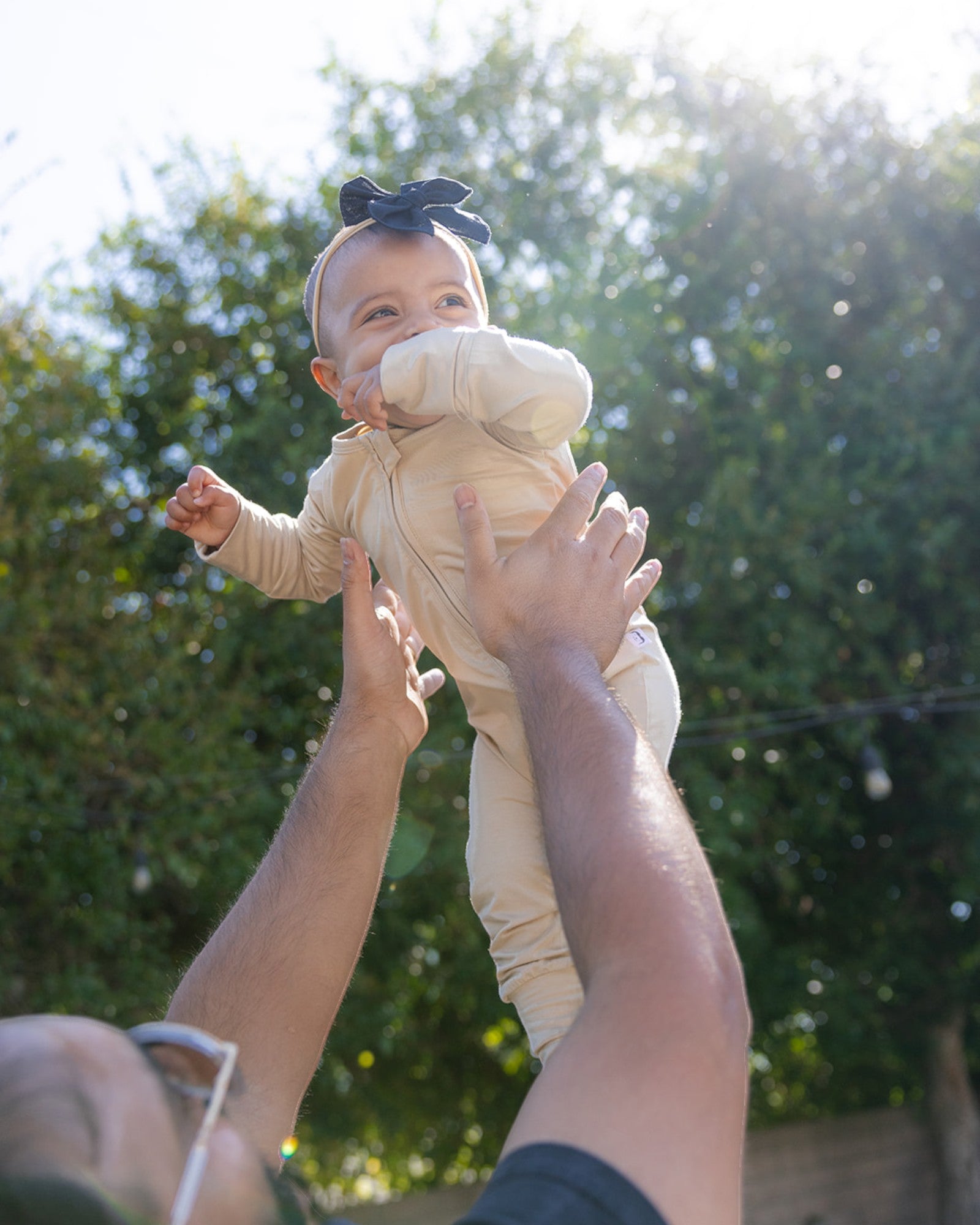 Baby wearing bamboo zip romper/sleeper in apricot beige color