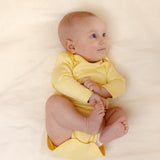 Baby wearing bamboo & organic cotton bodysuit and onesie in sunshine yellow color