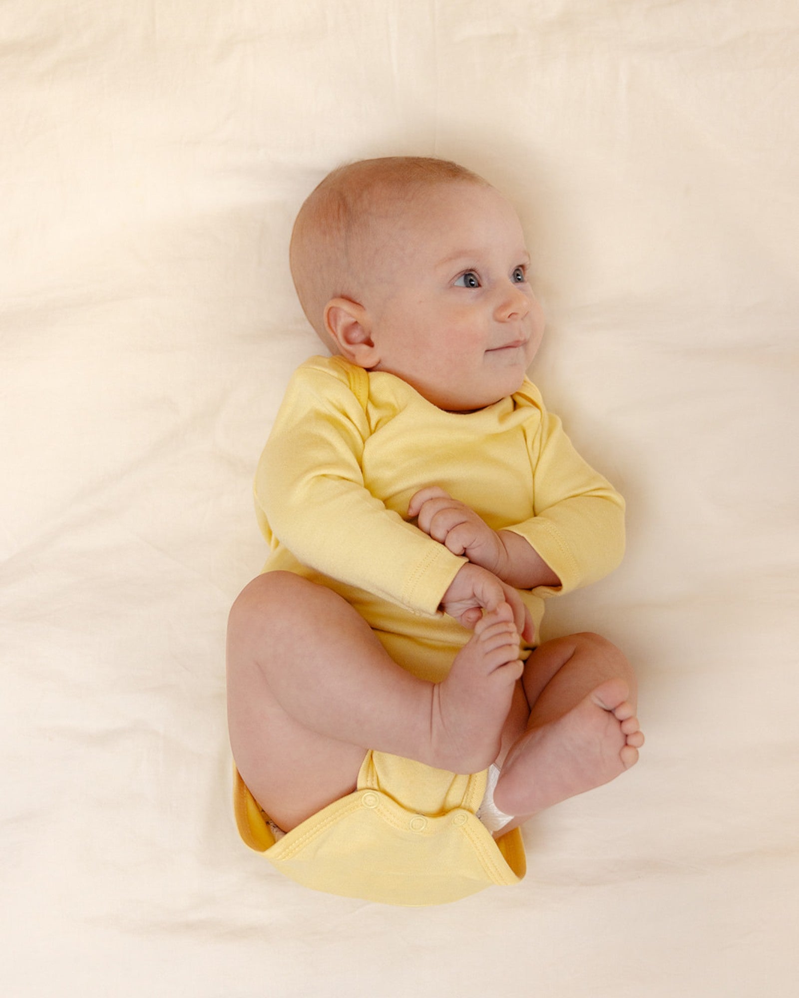Baby wearing bamboo & organic cotton bodysuit and onesie in sunshine yellow color