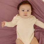 Baby wearing ballu baby bamboo onesie and bamboo swaddle blanket in lavender color