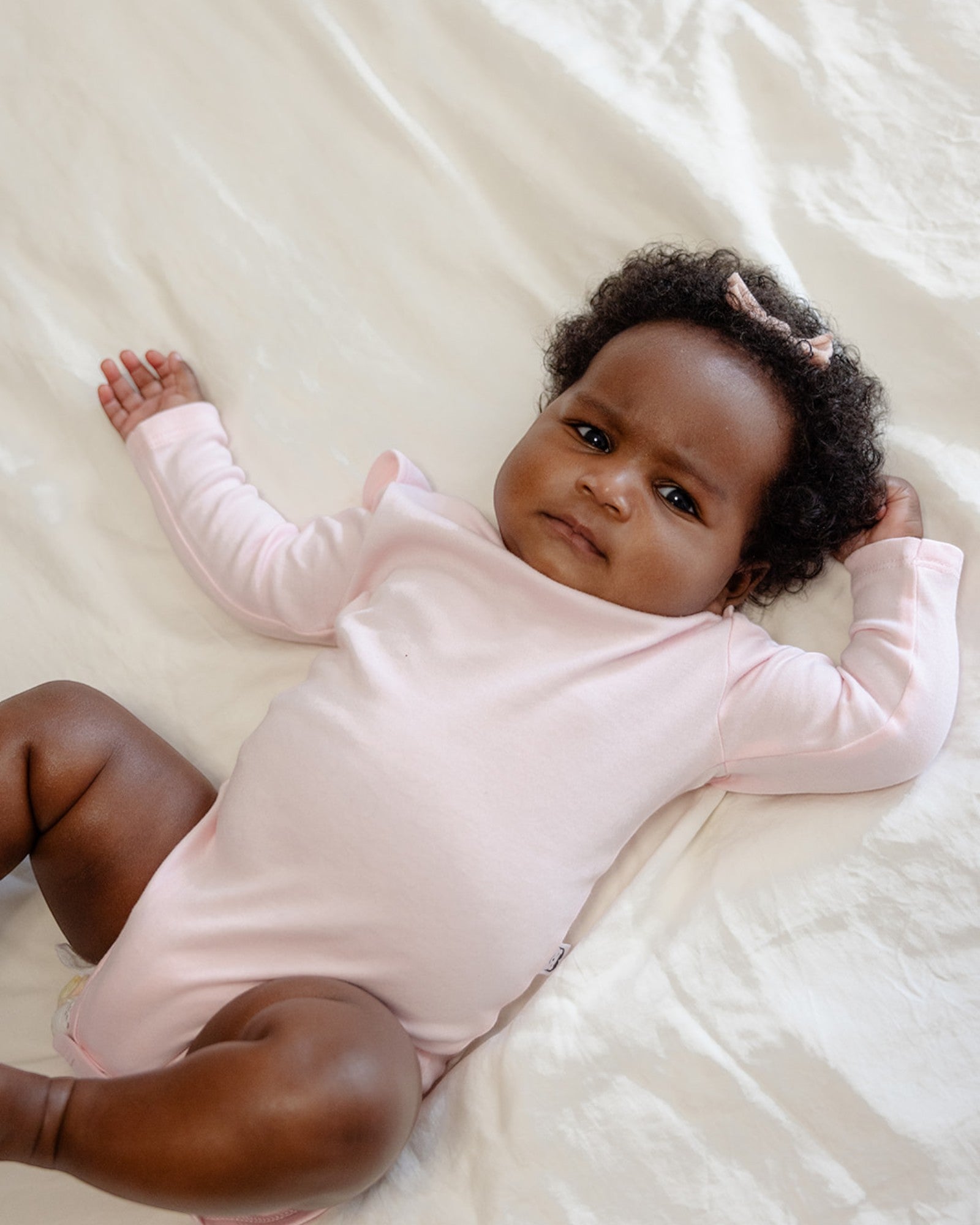 Baby wearing bamboo & organic cotton bodysuit and onesie in sakura pink color