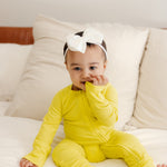 Baby wearing ribbed bamboo zipper romper in lemon yellow color