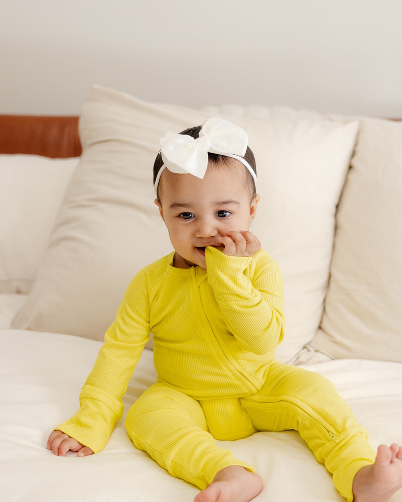 Baby wearing ribbed bamboo zipper romper in lemon yellow color