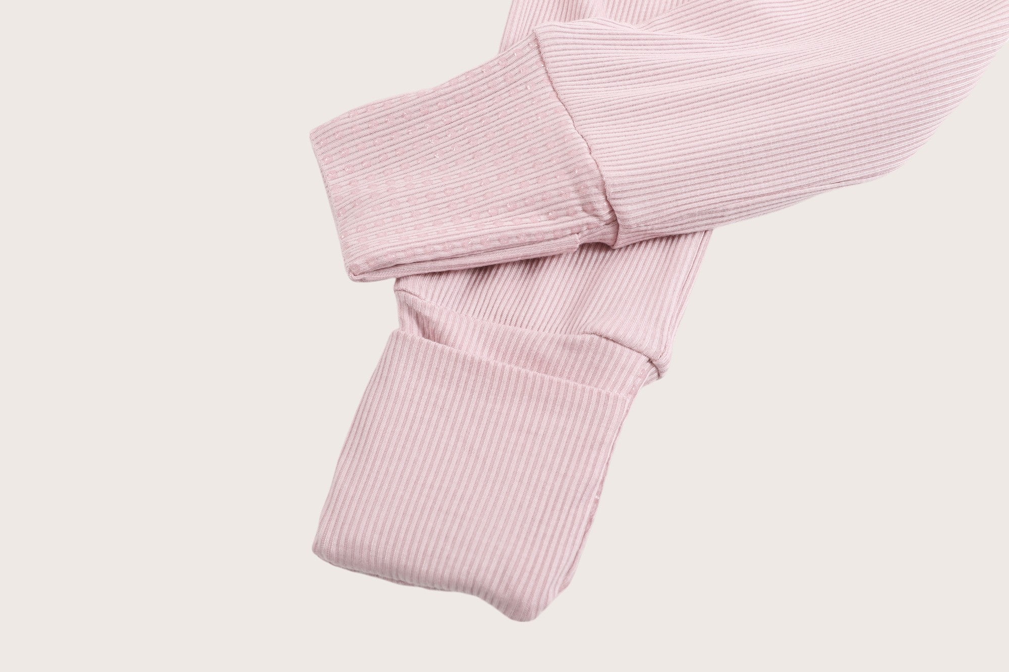 Ribbed bamboo zipper romper in blush pink color featuring fold over footies with grips