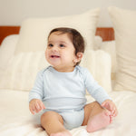 Baby wearing bamboo & organic cotton bodysuit and onesie in cloud color 