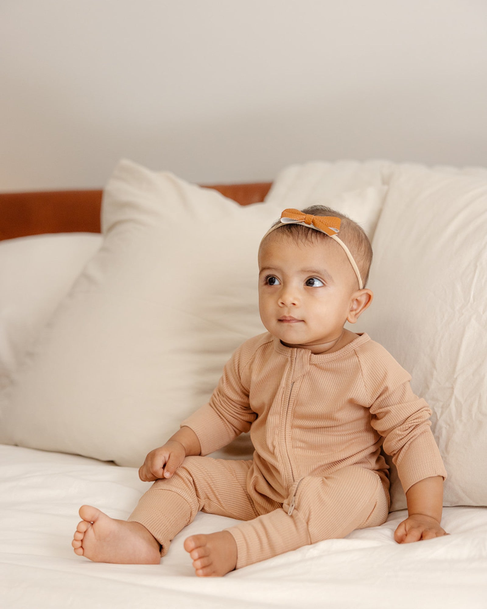 Baby wearing ribbed bamboo zipper romper in sand beige color
