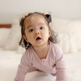 Baby wearing ribbed bamboo zipper romper in blush pink color 